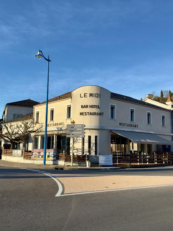 a building on the corner of a street with a street light at Hôtel le midi in Montaigu-de-Quercy
