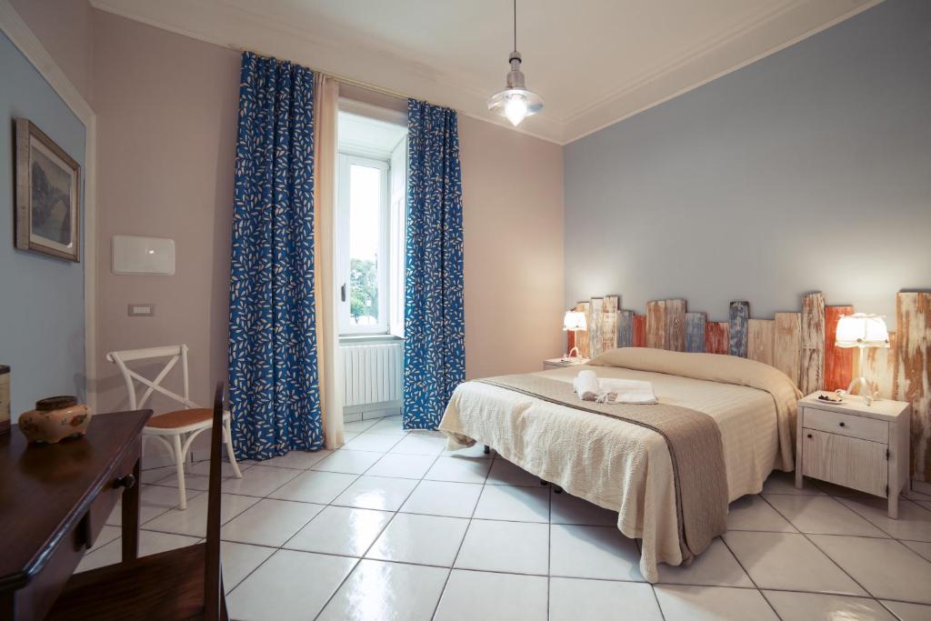 a bedroom with a bed and a window with blue curtains at La Tartaruga in Salerno