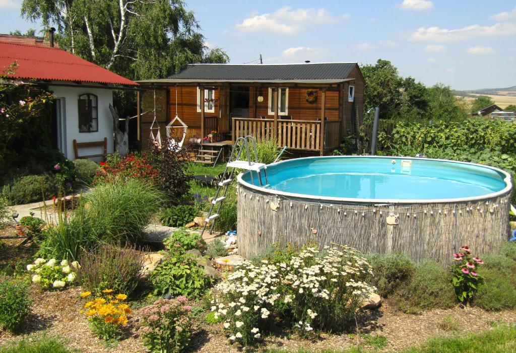 a garden with a hot tub in front of a house at Maringotka Matylda in Libčeves
