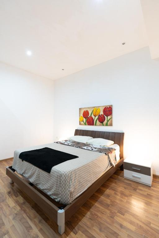 a bedroom with a bed and a painting on the wall at Blue Line Sliema in San Pawl il Bahar