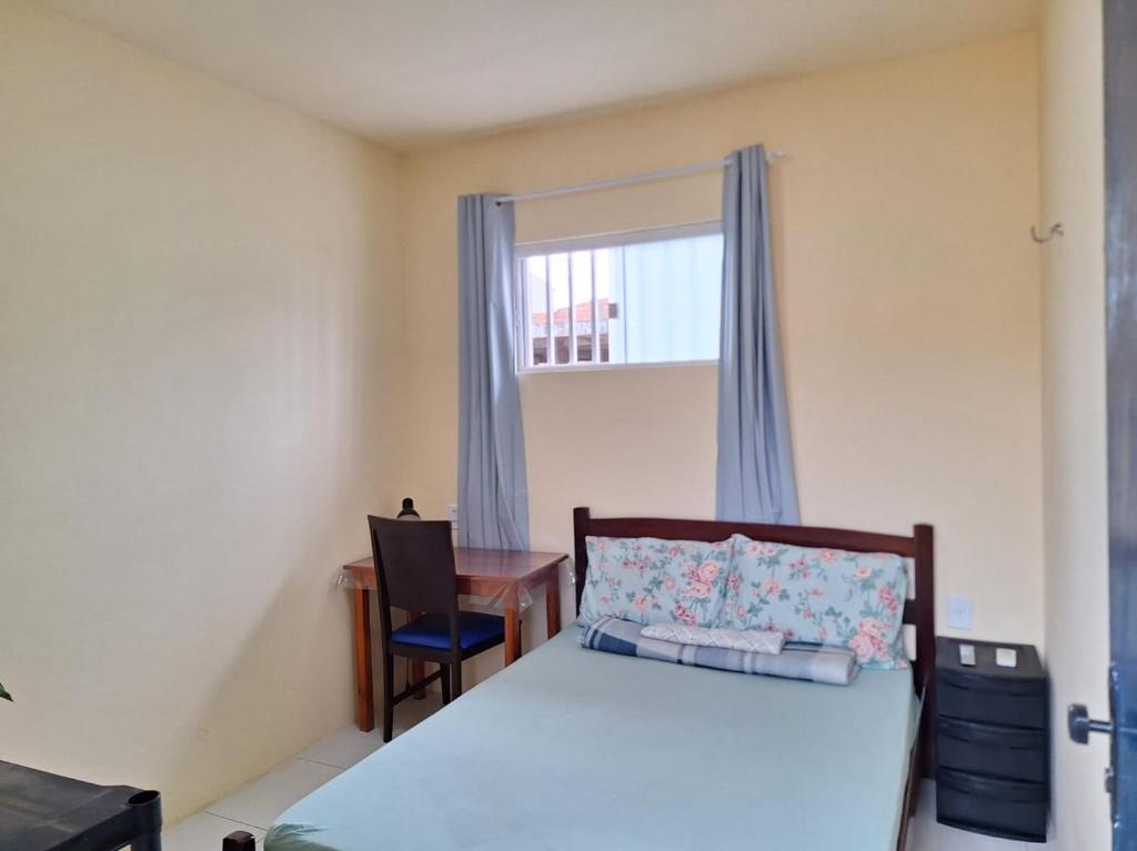 a bedroom with a bed and a desk and a window at Quarto TOP perto do Centro e Praias AR TV Wifi Cozinha Lavadora in São Luís