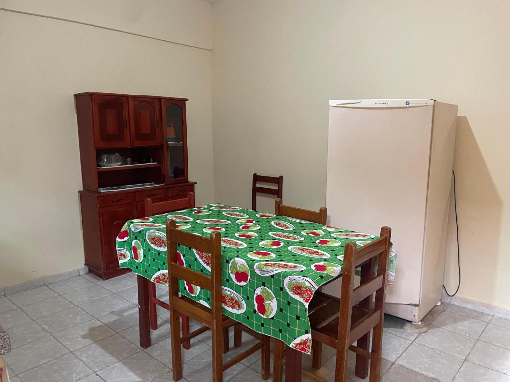 a kitchen with a table and a refrigerator at Apartamentos Dona Marlene in São Francisco de Itabapoana