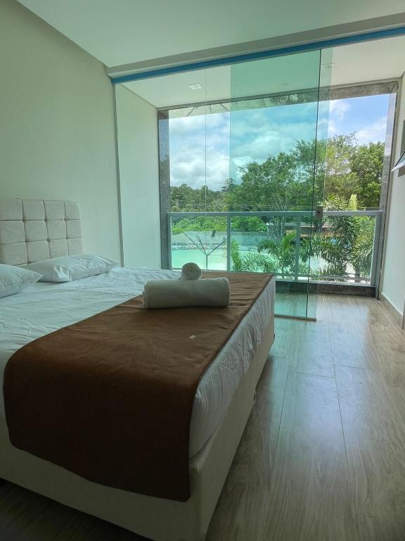a bedroom with a large bed with a large window at Rincão Resort in São Paulo