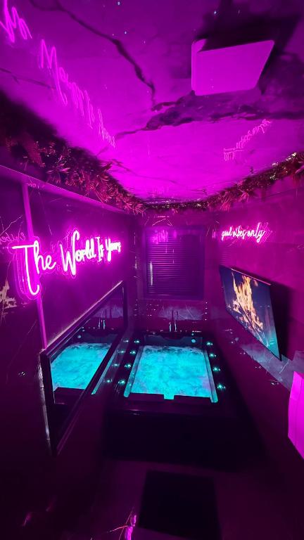 a room with two bowling lanes with purple lights at Nuit D Or LoveRoom in Bellegarde-sur-Valserine