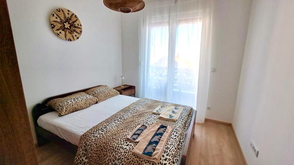 a bedroom with a bed and a clock on the wall at Upendo Apartment in Vrnjačka Banja