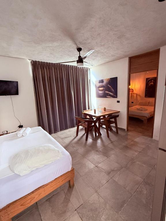 a bedroom with a bed and a table in it at condo pacha tulum in Tulum