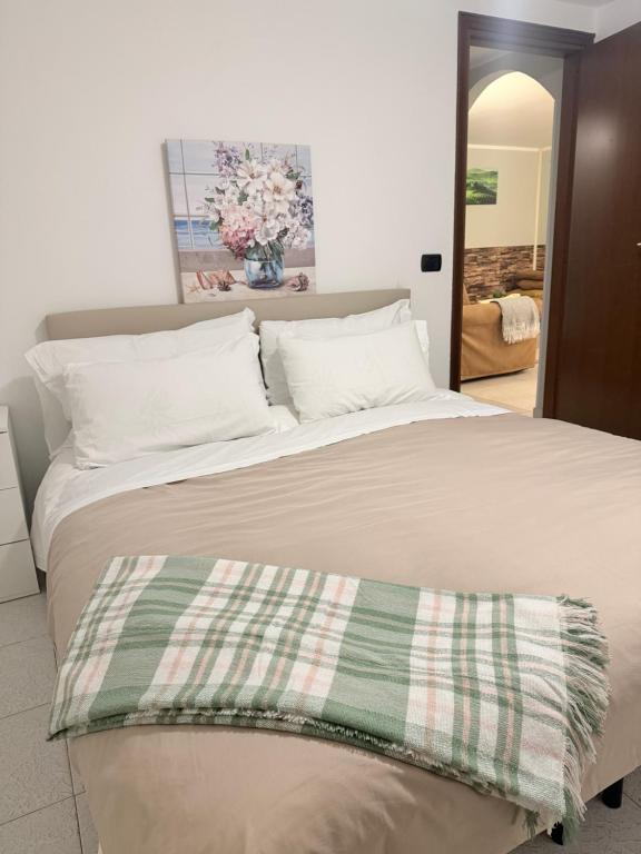 a large bed with a green and white blanket on it at Bellagio Little Apartment in Bellagio