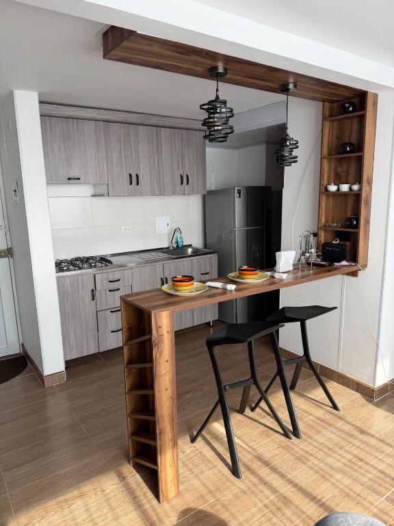 a kitchen with a wooden island in a room at Descansa, comodidad y confort in Manizales