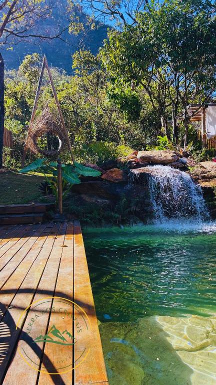 a waterfall in front of a pond with a swing at loft Ágata in Brumadinho