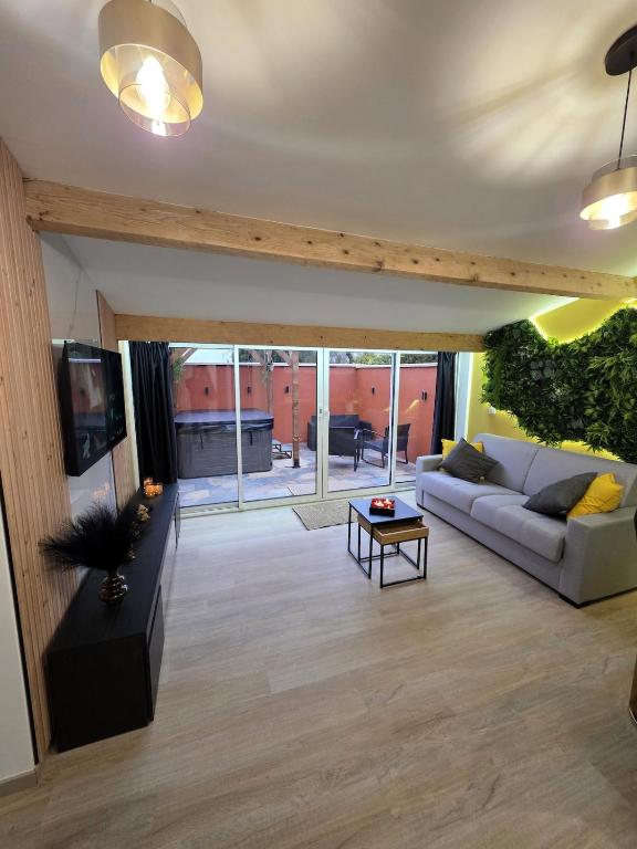 a living room with a couch and a table at Le Baiser Doré in Sainte-Marie-aux-Chênes
