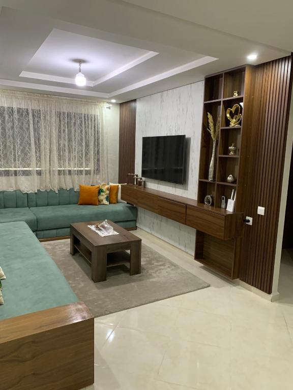 a living room with a couch and a tv at bel appartement juste à côté de McDonald's in Kenitra