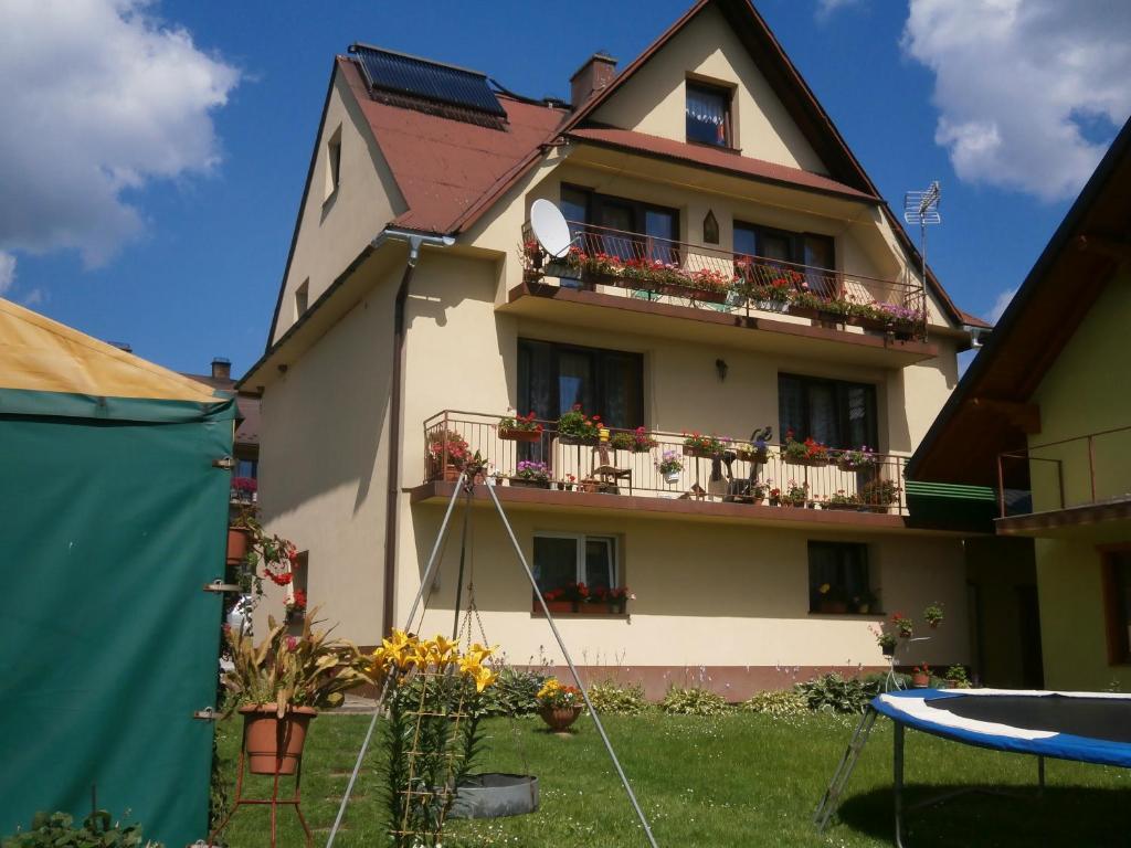 a house with flowers on the side of it at Pod Cisowcem in Sromowce Wyżne