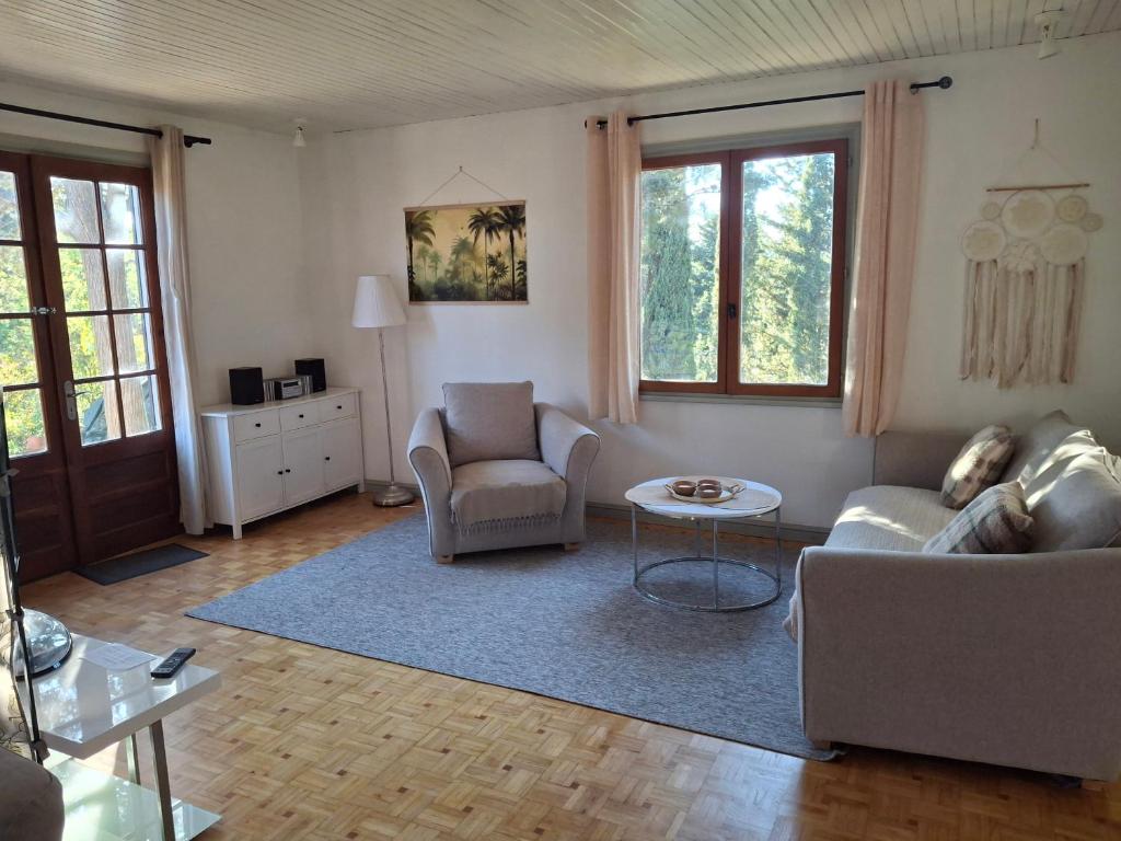 a living room with a couch and chairs and a table at LES CIGALINES Chalet au calme in Fabrezan