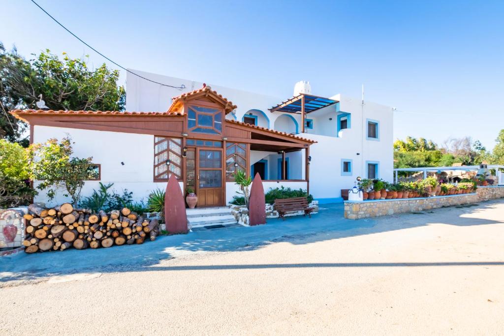 a house with a porch and a fence at Barbarossa Apartments in Vrachonisída Prasonísi
