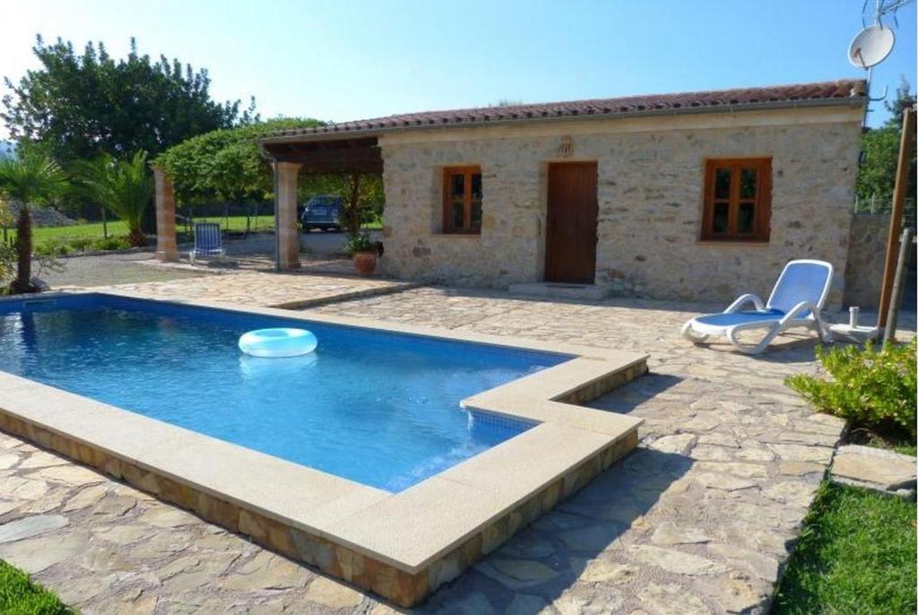 a swimming pool in front of a house at Casa Villa Las Encinas in Pollença