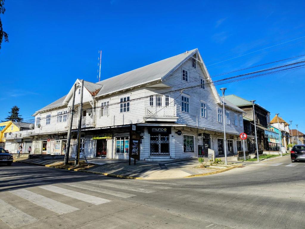 an old white building on the corner of a street at Her Home in Purranque