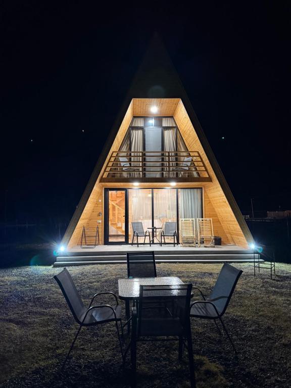 a house with a table and chairs in front of it at WoodCottage in Borjomi