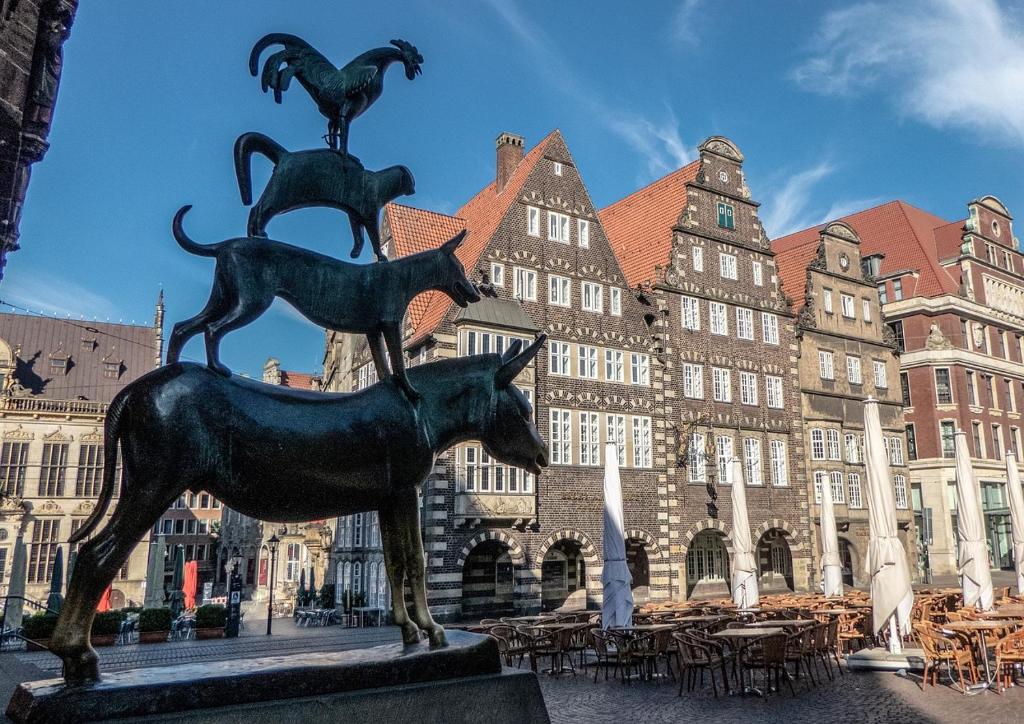a statue of three dogs on a horse in front of a building at Strand Hotel Deichläufer in Butjadingen