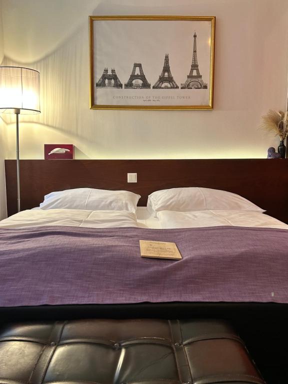 a bedroom with a bed with a picture of the eiffel tower at Pension Stadthalle in Vienna