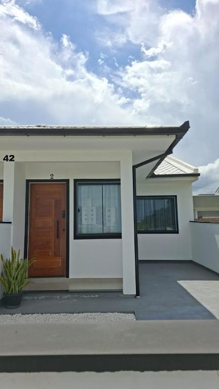a small house with a brown door on a building at Casa42 aconchego perto de Florianópolis in Palhoça