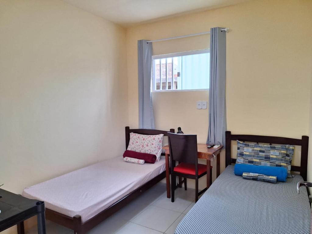 a room with a bed and a desk and a window at Quarto UP perto do Centro e Praias AR TV Wifi Cozinha Lavadora in São Luís