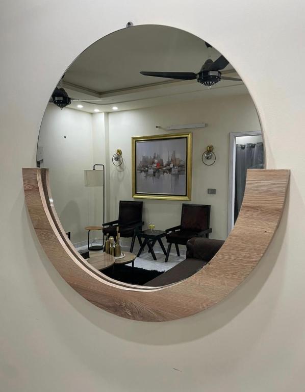 a large circular mirror on a wall in a living room at Riverhills Comfort 2BHK in Rawalpindi