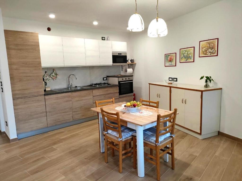 a kitchen with a table and chairs in a room at La bottega del sarto in Grumes