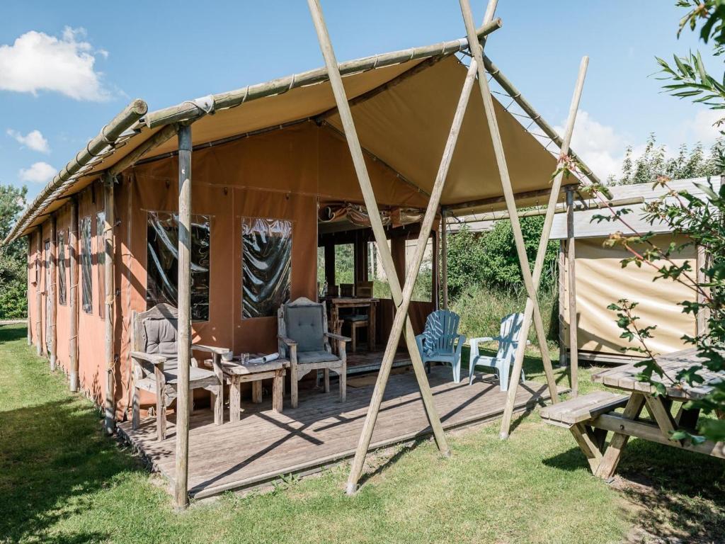 a tent with chairs and a table in a yard at 6-person Duynlodge Tent in Callanstoog in Callantsoog