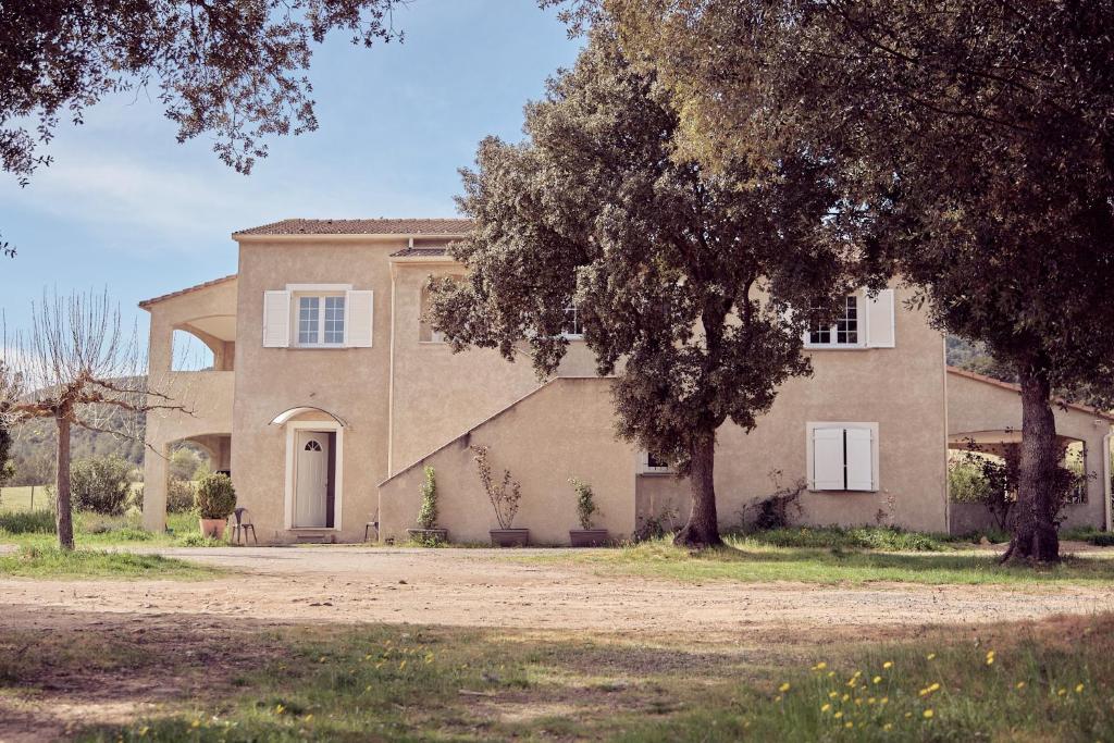 a large house with a tree in front of it at La ferme in Moltifao