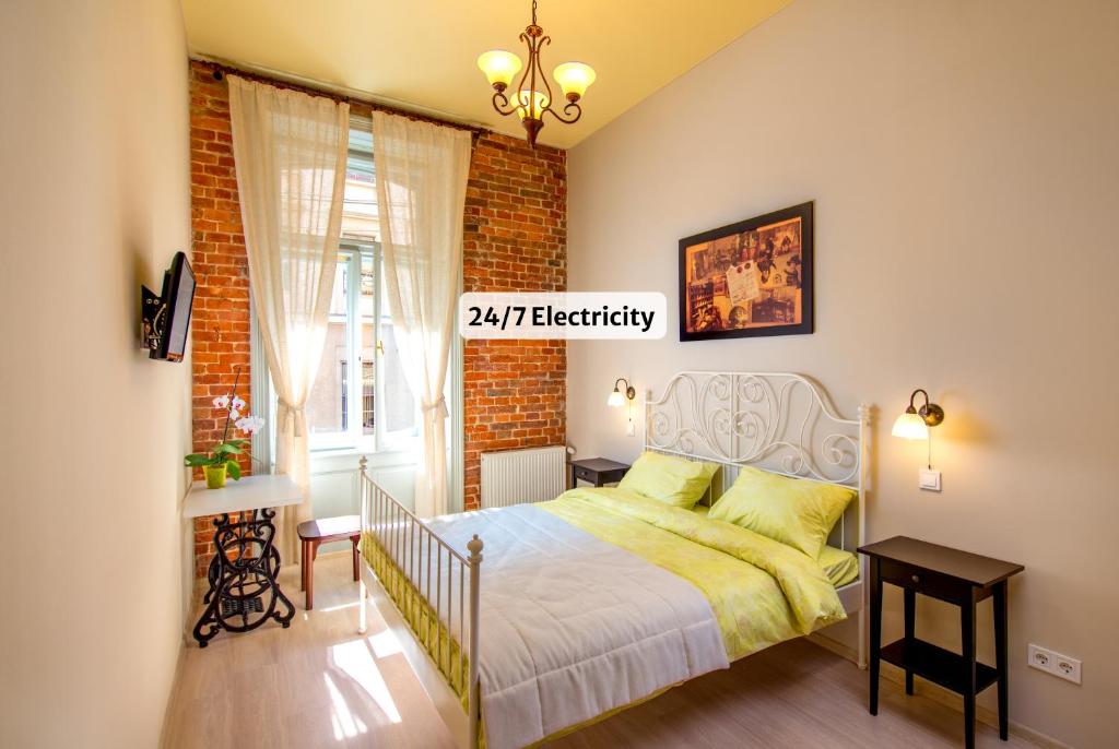 a bedroom with a bed and a brick wall at Post House Rooms in Lviv