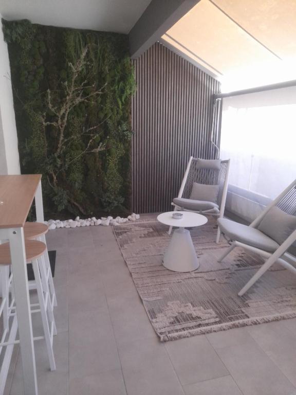 a patio with two chairs and a table and a plant at Nature Nest in Larisa