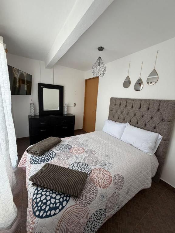 ein Schlafzimmer mit einem großen Bett und einem Fernseher in der Unterkunft Apartamento 32 in Toluca de Lerdo