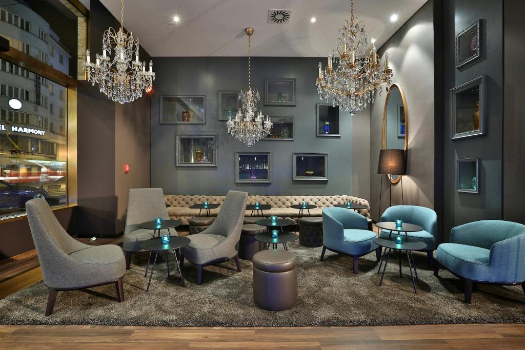 a restaurant with blue chairs and tables and chandeliers at Motel One Prague-Florentinum in Prague