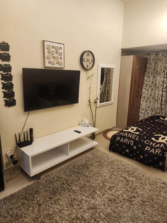 a living room with a tv on the wall and a bed at Ajman Luxury Downtown B9OO7 in Ajman 