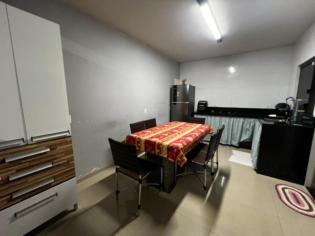 a kitchen with a table with chairs and a refrigerator at Casa Completa brutomesso 3 in Londrina