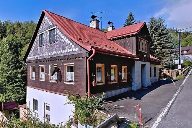 a brown and white house with a red roof at Sauna Chata BedRich in Bedřichov