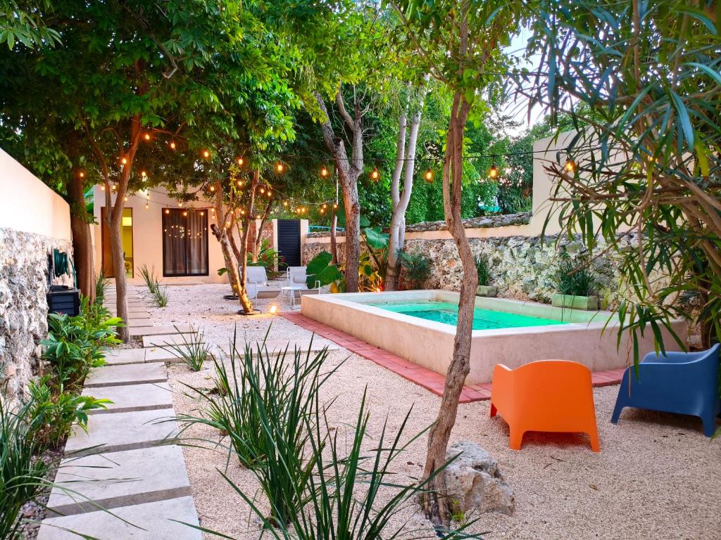 a backyard with a pool and a chair and trees at Villa Lara Palacios, tu oasis en Mérida in Mérida