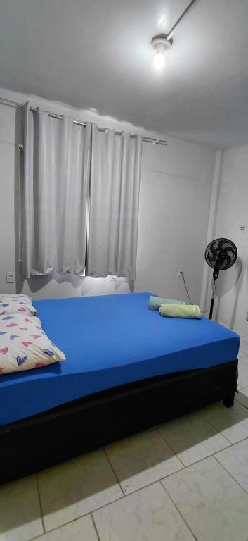 a blue bed in a room with a window at Pousada Familiar 04 in Rio do Sul