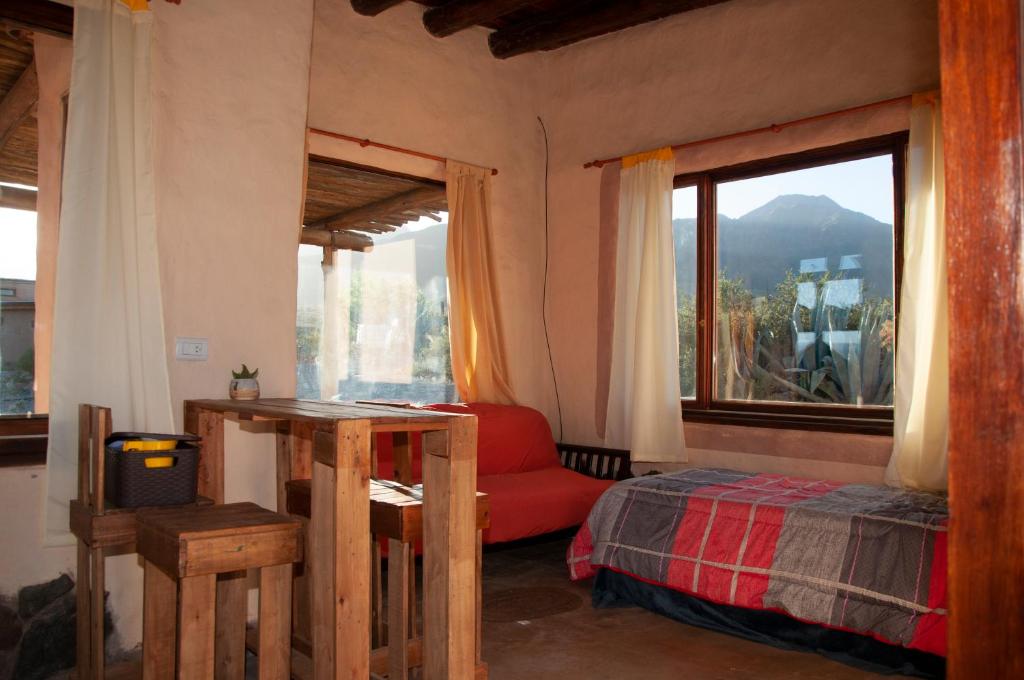 ein Schlafzimmer mit einem Bett und einem großen Fenster in der Unterkunft CABAÑAS KONDUR Elementos in Ciudad Lujan de Cuyo