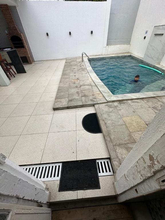 a swimming pool with a person in the water at Casa Ampla e aconchegante Limoeiro in Limoeiro