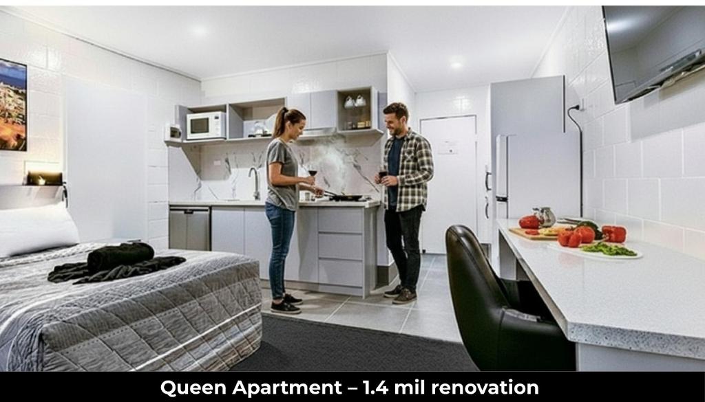 two people standing in a kitchen in a room at Aaron Motel in Gladstone