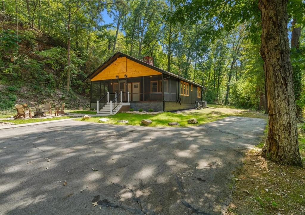 a small house in the middle of a forest at Hill Top Forest Cabin with Hot Tub, Fire Pit & Screened Porch in Pigeon Forge