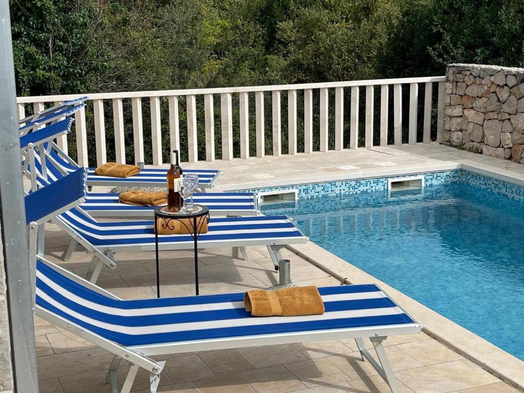 a group of chairs sitting next to a swimming pool at Villa Leen Dubrovnik in Ðurinići