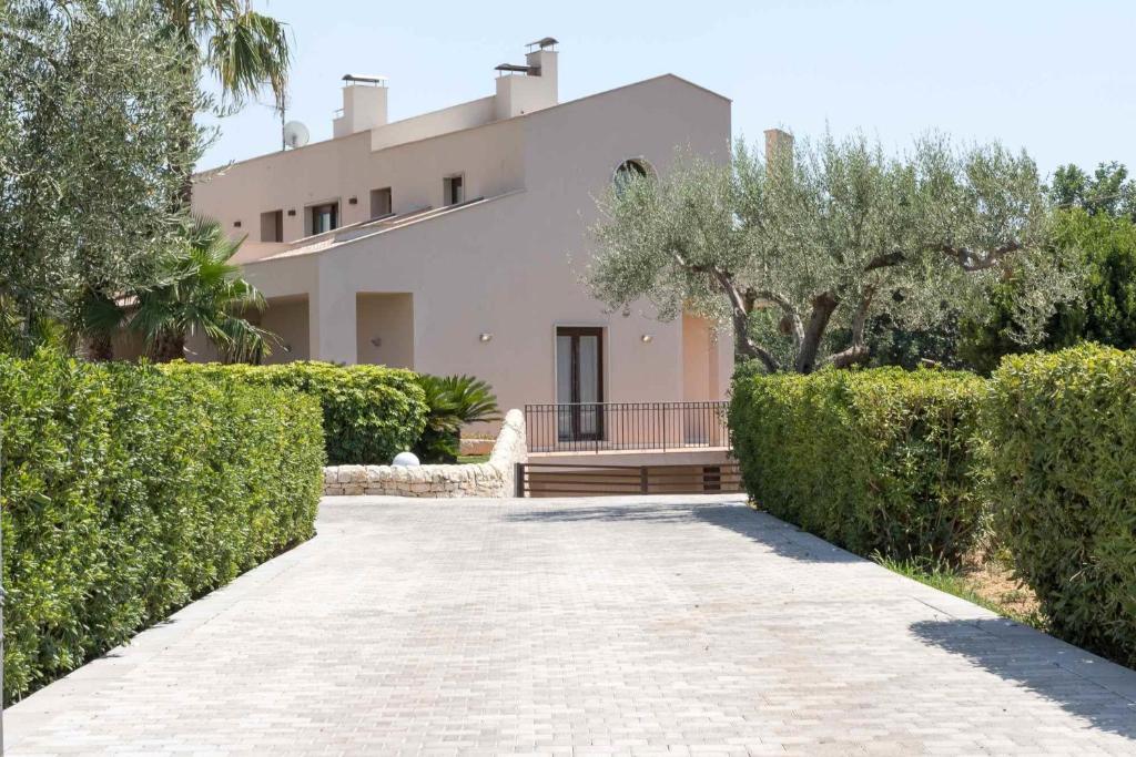 a house with a walkway in front of a building at Sammit holiday home in Modica