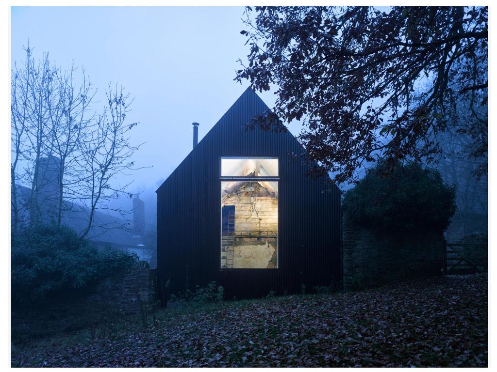 a small black house with a window in a field at Croft Lodge Studio in Leominster