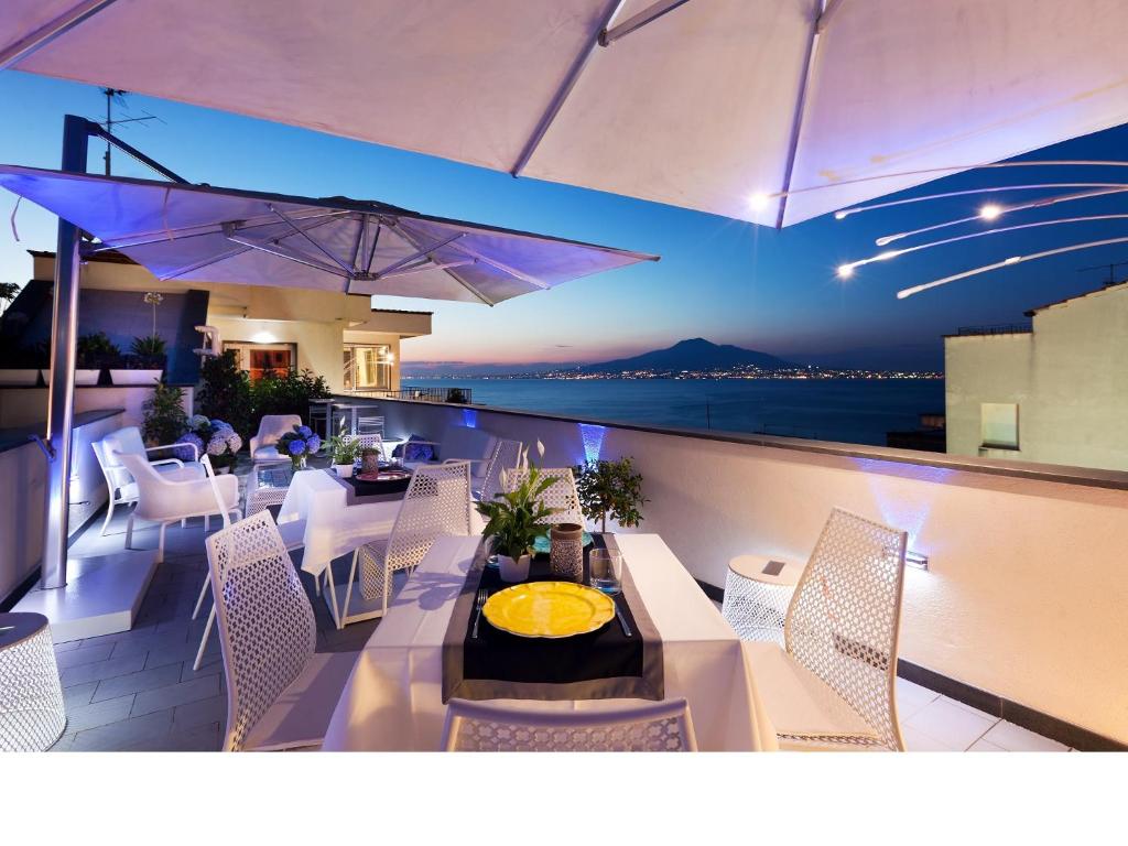 balcón con mesa, sillas y vistas al océano en Cubo Apartments, en Vico Equense