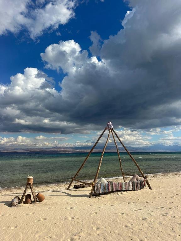 a makeshift tent on a beach with the ocean at Baywatch Camp in Nuweiba
