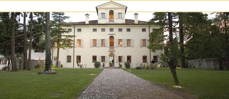 Una gran casa blanca con una torre encima. en Villa Cigolotti en Vivaro