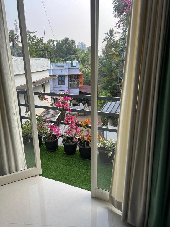 an open window with potted plants on a balcony at Samriddhi Homestay in Trivandrum