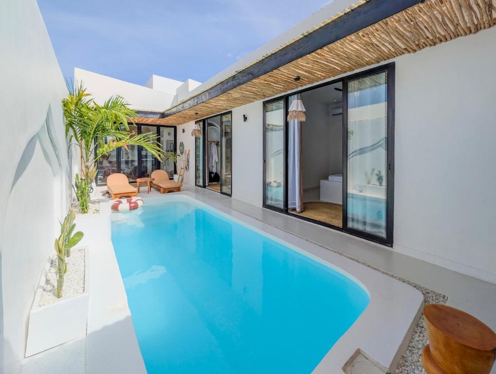 an indoor pool with blue water in a house at Marram Villas 3 Prime Location in Paje